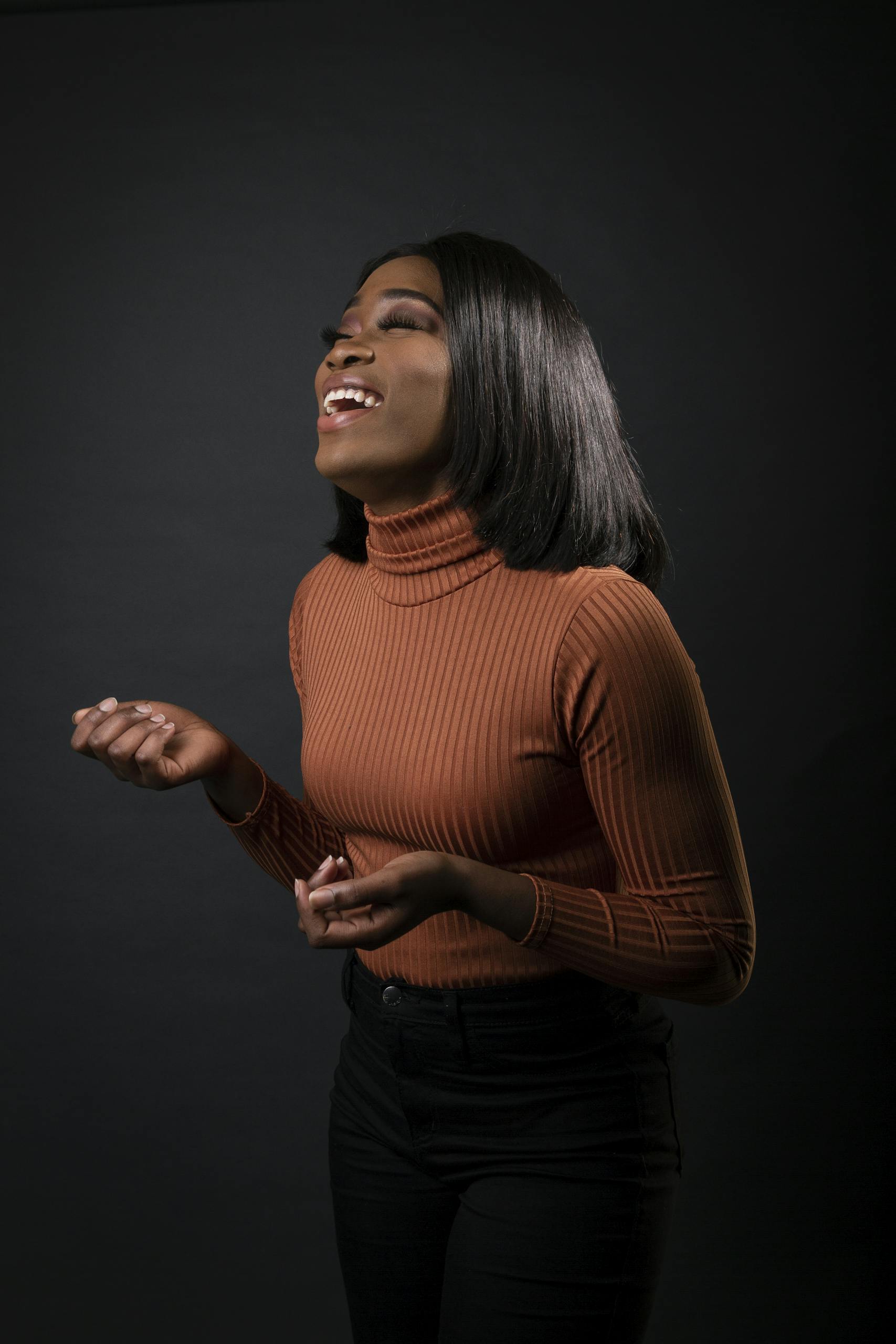 A joyful woman in a stylish outfit laughing, captured in a portrait setting. Perfect for fashion and lifestyle themes.